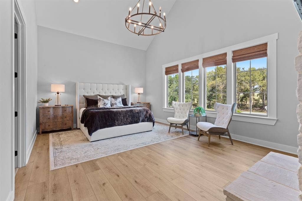 23180 Bridle View Drive, Lindale, TX 75771 Vaulted ceiling with an open-cage chandelier, wood-finish flooring, and a wall of windows