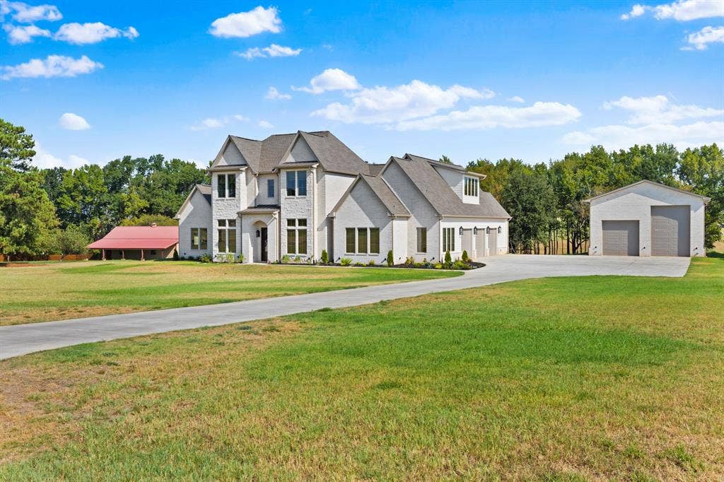 23180 Bridle View Drive, Lindale, TX 75771 Stately residence with a light-colored brick exterior, prominent gables, and a dark roof
