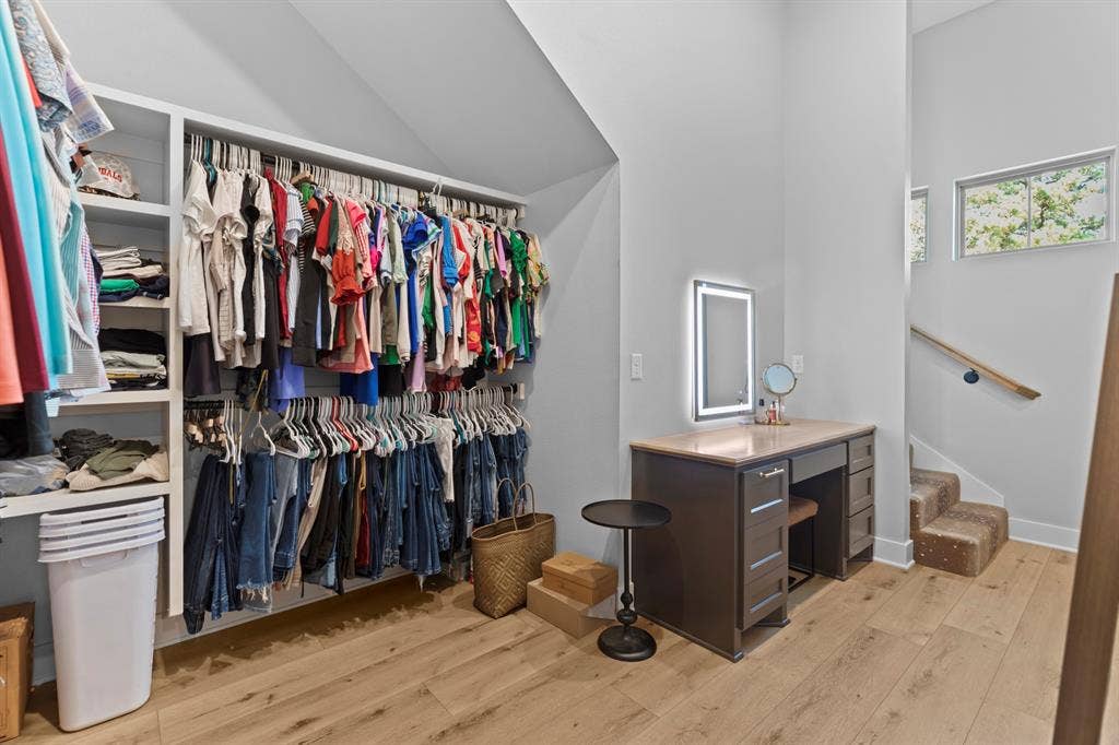 23180 Bridle View Drive, Lindale, TX 75771 Custom closet organization system, wood-finish flooring, built-in vanity with illuminated mirror, light wood handrail, and carpeted stairs