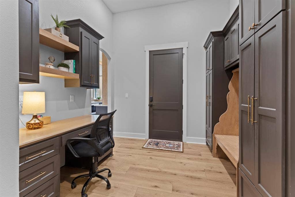 23180 Bridle View Drive, Lindale, TX 75771 Built-in desk area with dark cabinetry, integrated open shelving, and light wood-finish countertop