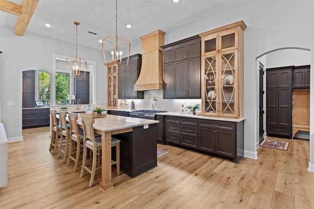 23180 Bridle View Drive, Lindale, TX 75771 Spacious kitchen featuring a large island, wood-finish flooring, recessed lighting, and mixed-material cabinetry with display fronts