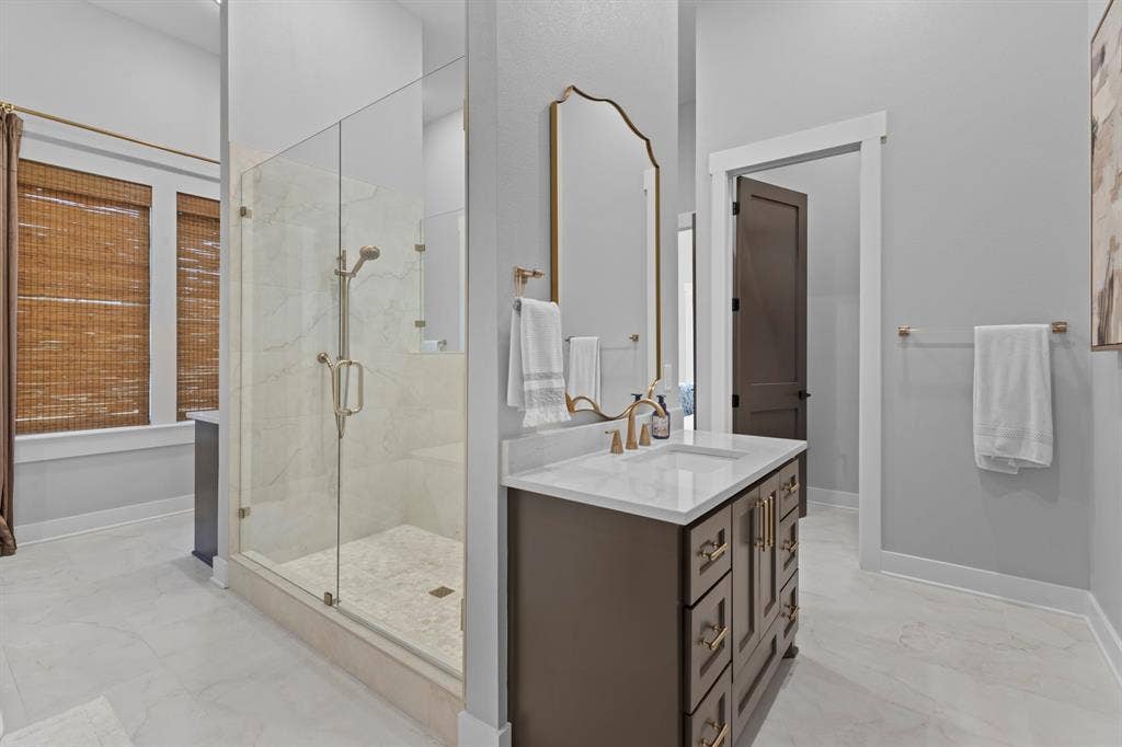 23180 Bridle View Drive, Lindale, TX 75771 Glass-enclosed shower with marble-finish tile, a single vanity with quartz countertop, and white tile flooring