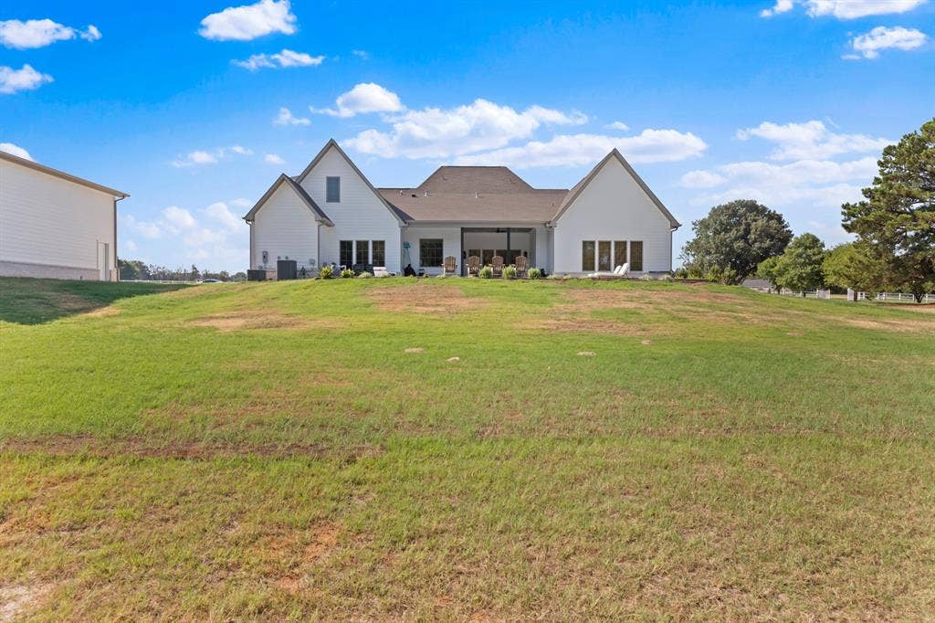 23180 Bridle View Drive, Lindale, TX 75771 White exterior with dark roof, multiple gabled sections, and a covered patio area