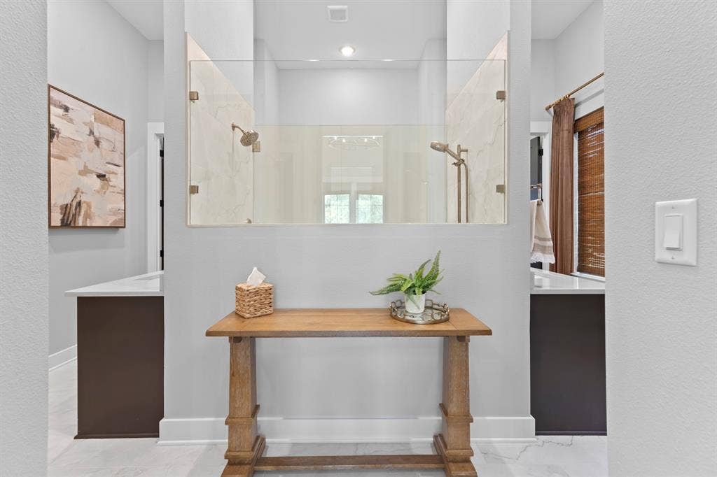 23180 Bridle View Drive, Lindale, TX 75771 Dual walk-in shower with glass enclosure, two separate vanities with white countertops, and wood-finish flooring