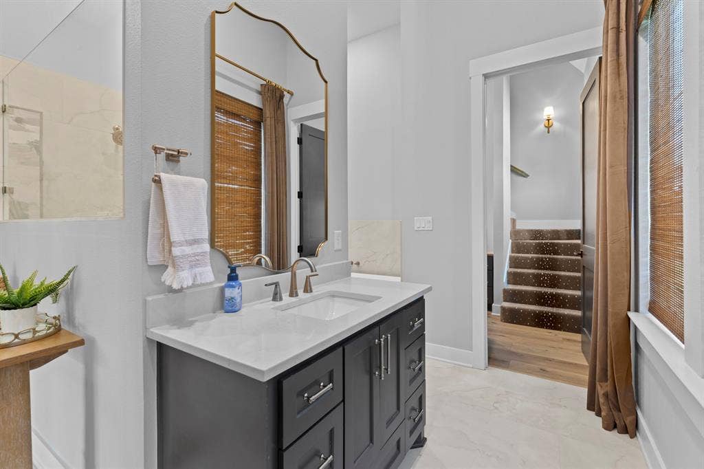 23180 Bridle View Drive, Lindale, TX 75771 Vanity with a light-toned countertop, brushed nickel faucet, and dark cabinetry