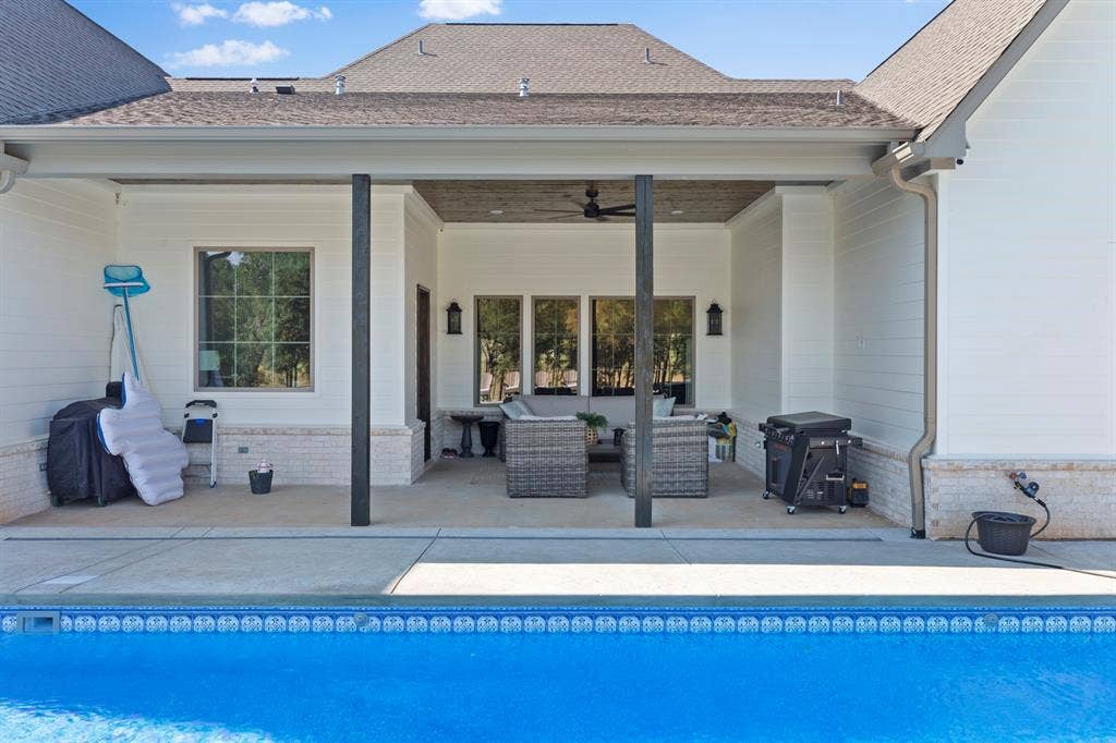 23180 Bridle View Drive, Lindale, TX 75771 Outdoor concrete patio with recessed lighting and a ceiling fan, featuring an adjacent swimming pool with a tiled edge