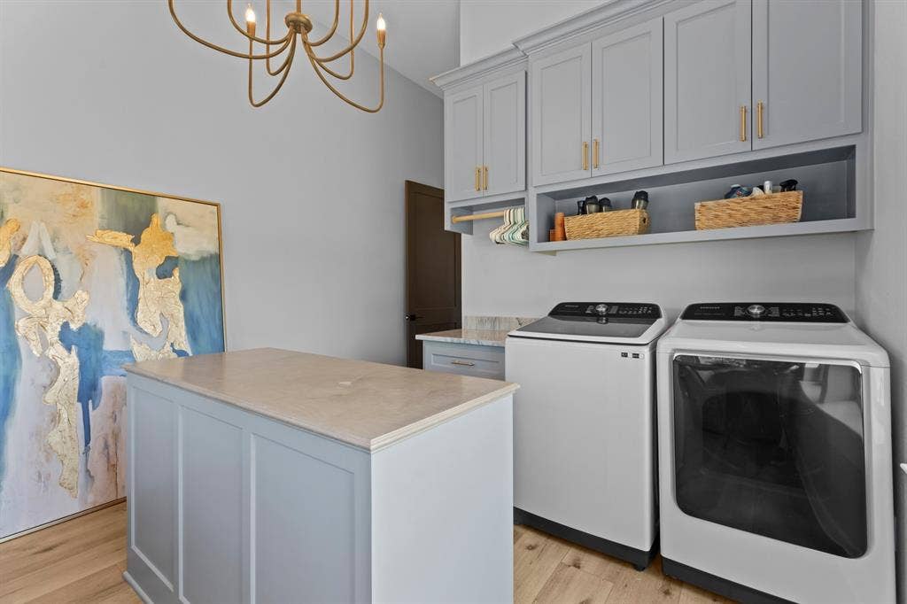 23180 Bridle View Drive, Lindale, TX 75771 Laundry room with wood-finish flooring, built-in cabinetry, and a central island with a solid surface countertop