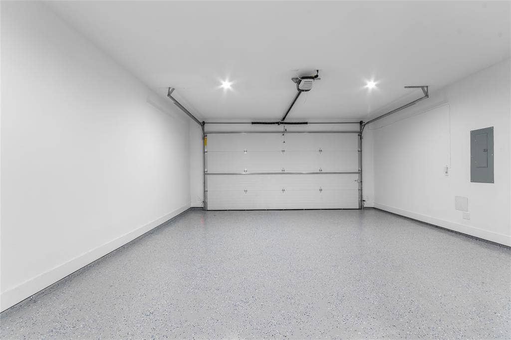 Garage featuring an automatic overhead door, recessed lighting, and a durable speckled epoxy floor finish