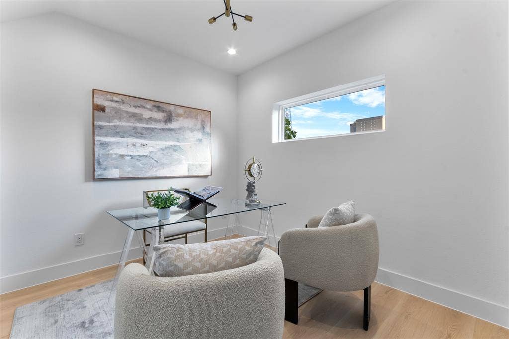 Dedicated room featuring light wood-finish flooring, a contemporary horizontal window, and a modern light fixture