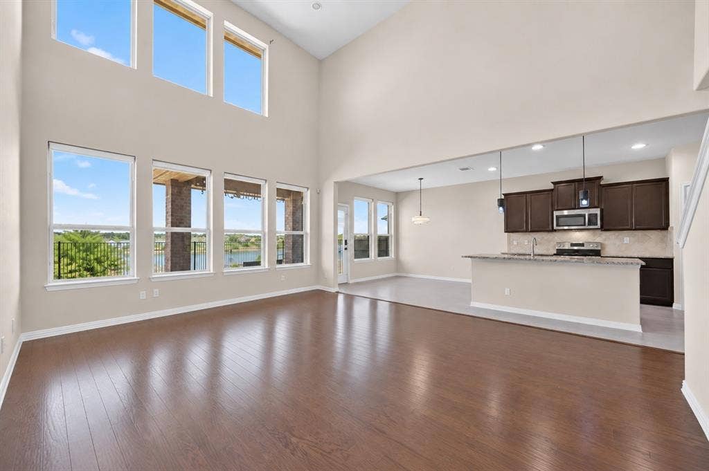 2025 Lake Front Trail, Garland, TX 75043 Vaulted ceiling, expansive windows, wood-finish flooring, kitchen island with built-in sink, stainless steel appliances
