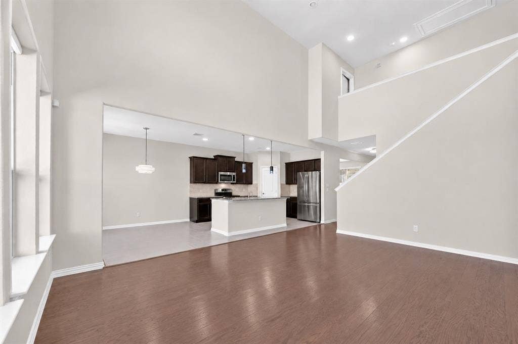 2025 Lake Front Trail, Garland, TX 75043 Vaulted ceilings, wood-finish flooring, kitchen island with seating, stainless steel appliances, and a second-story landing