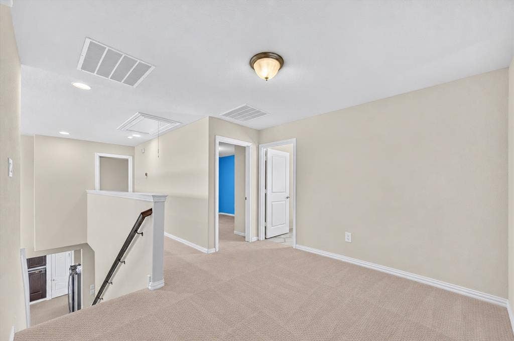 2025 Lake Front Trail, Garland, TX 75043 Carpeted landing with white trim, a semi-flush ceiling light, and stair railing