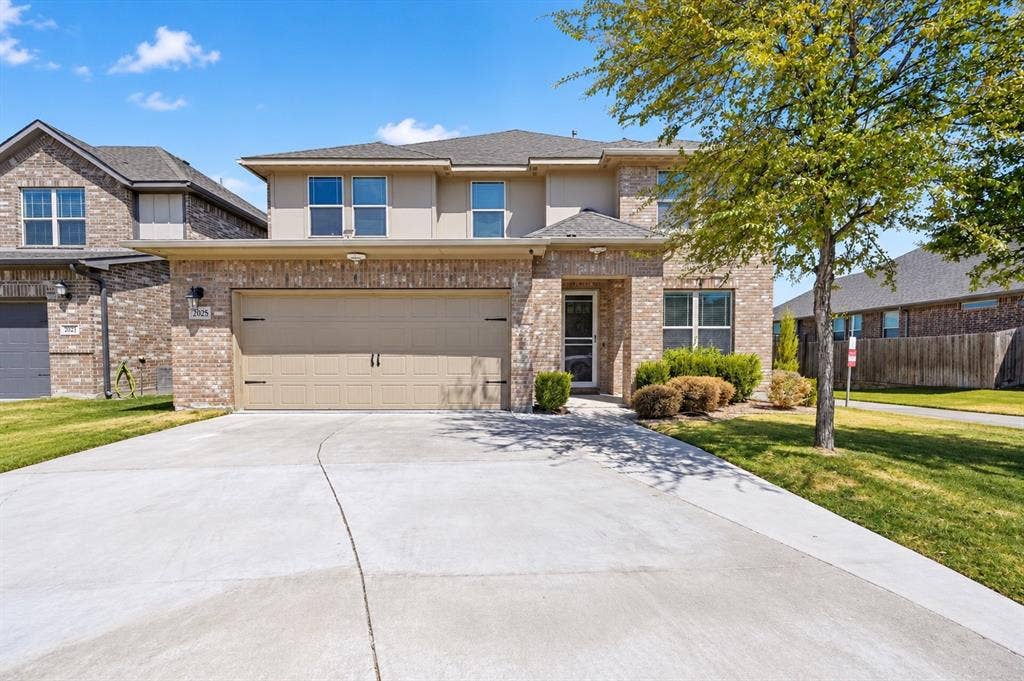 2025 Lake Front Trail, Garland, TX 75043 Brick facade with stucco accents, an attached two-car garage, and a concrete driveway