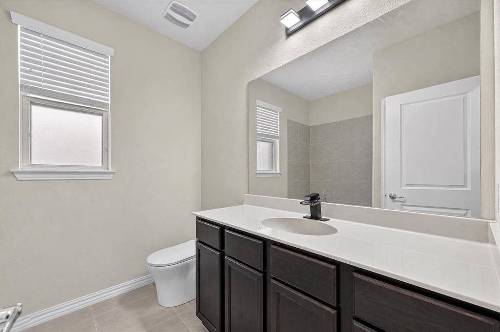 2025 Lake Front Trail, Garland, TX 75043 Single vanity with a white countertop, dark wood-finish cabinetry, and a black faucet