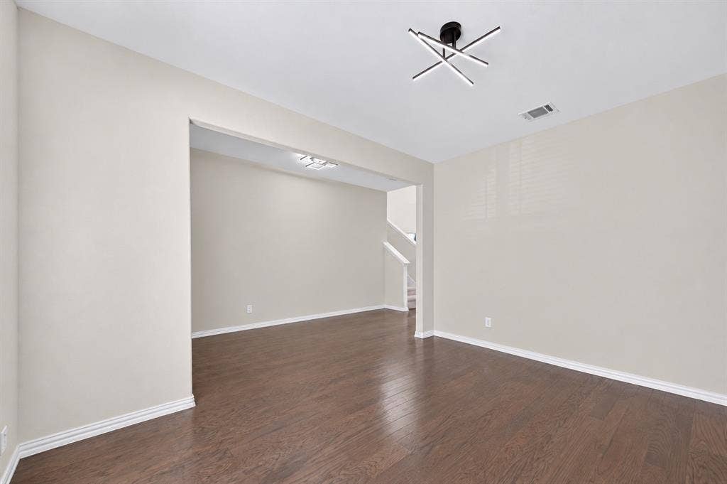 2025 Lake Front Trail, Garland, TX 75043 Wood-finish flooring, neutral wall paint, contemporary ceiling light fixture, white trim, and an open entryway