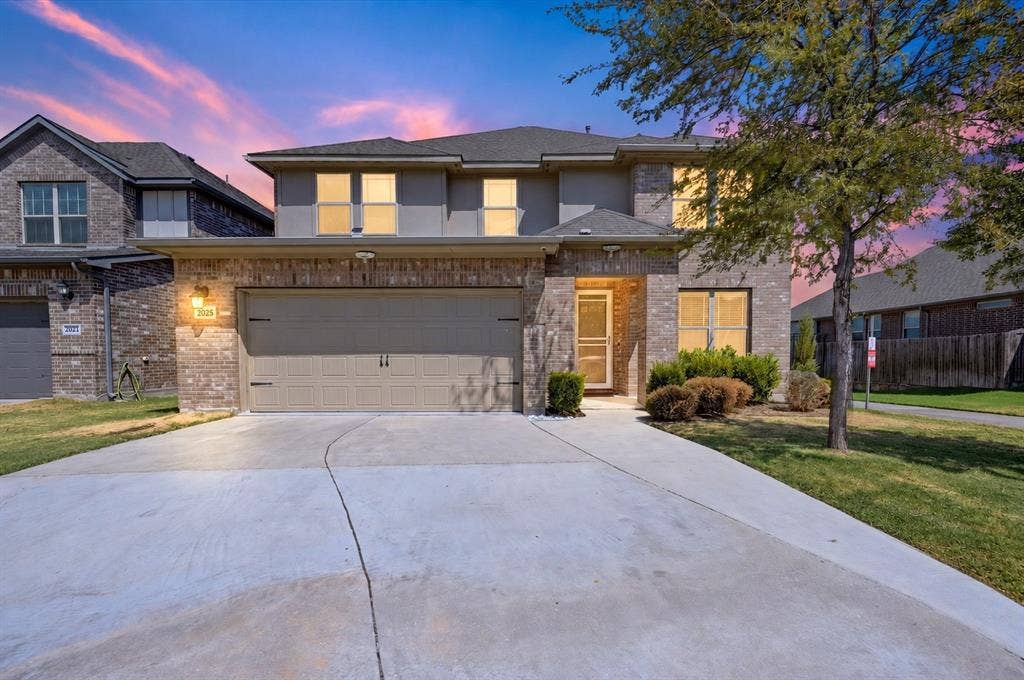 2025 Lake Front Trail, Garland, TX 75043 Brick exterior with a two-car garage, concrete driveway, and covered front entry