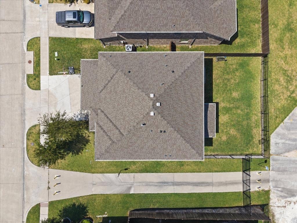 2025 Lake Front Trail, Garland, TX 75043 Pitched roof with multiple vents, concrete driveway, manicured lawn, and perimeter fencing