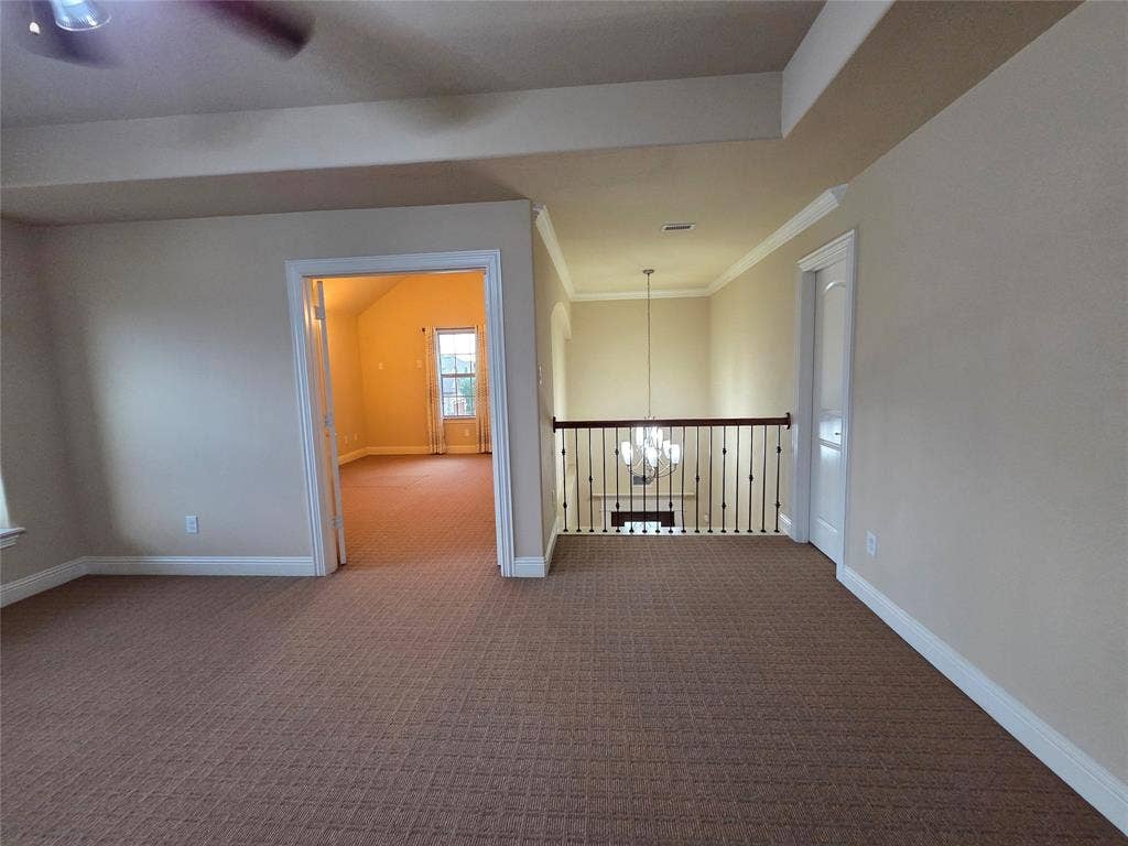 146 Rolling Fork Bend, Irving, TX 75039 Carpeted loft area with wrought iron baluster railing, white trim, and a ceiling fan