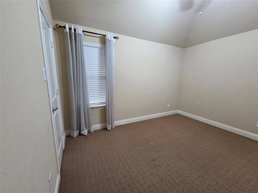 146 Rolling Fork Bend, Irving, TX 75039 Carpeted flooring with light-toned walls, a single window with blinds and drapes, and a vaulted ceiling