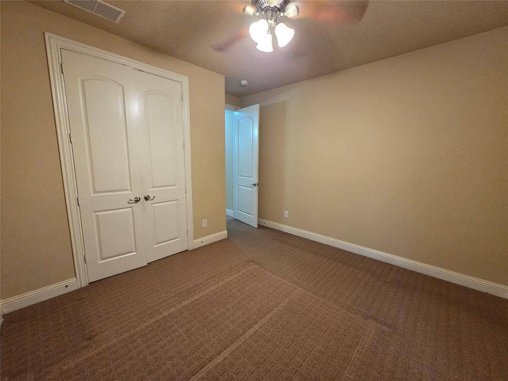 146 Rolling Fork Bend, Irving, TX 75039 Carpeted room featuring a ceiling fan with integrated lighting, a double-door closet, and white baseboards