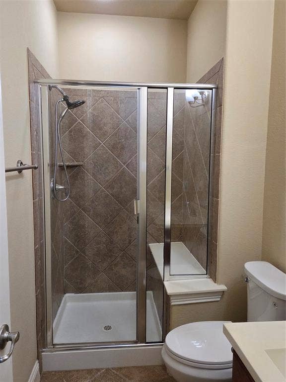 146 Rolling Fork Bend, Irving, TX 75039 Modern bathroom featuring a frameless glass-enclosed shower with diagonal tile surround, white ceramic pedestal sink, and white porcelain toilet