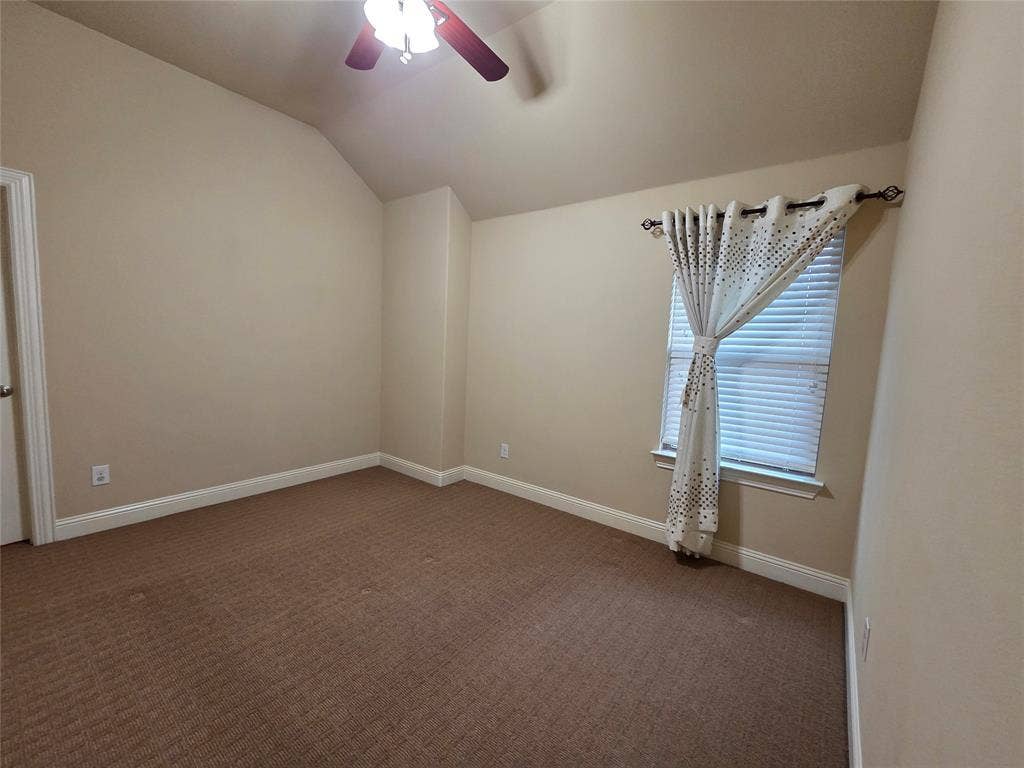 146 Rolling Fork Bend, Irving, TX 75039 Carpeted room featuring a ceiling fan, vaulted ceiling, and a window with blinds