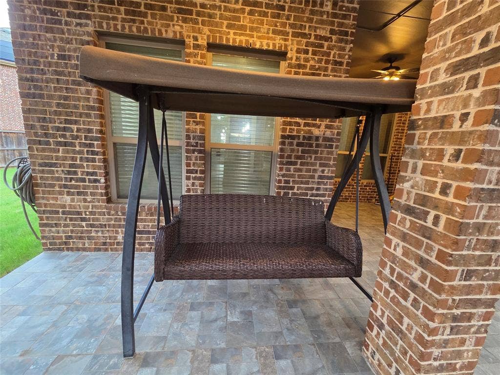146 Rolling Fork Bend, Irving, TX 75039 Covered patio featuring a brick exterior, stone tile flooring, and a ceiling fan