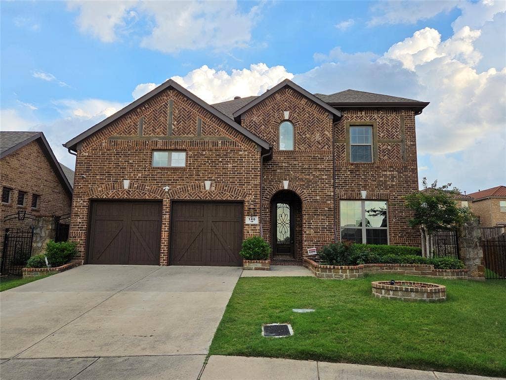 146 Rolling Fork Bend, Irving, TX 75039 Brick exterior with decorative accents, arched entry, dual garage doors, paved driveway, and manicured landscaping