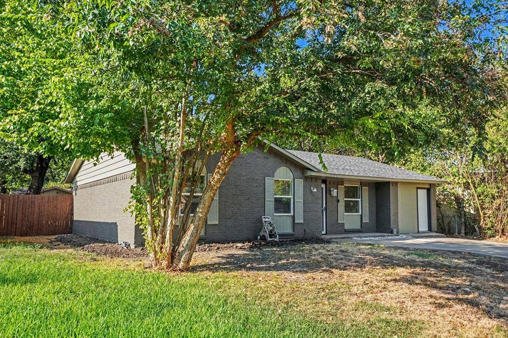 2429 February Lane, Grand Prairie, TX 75050 Single-story residence featuring a gray brick and siding exterior, arched window, and a covered entry