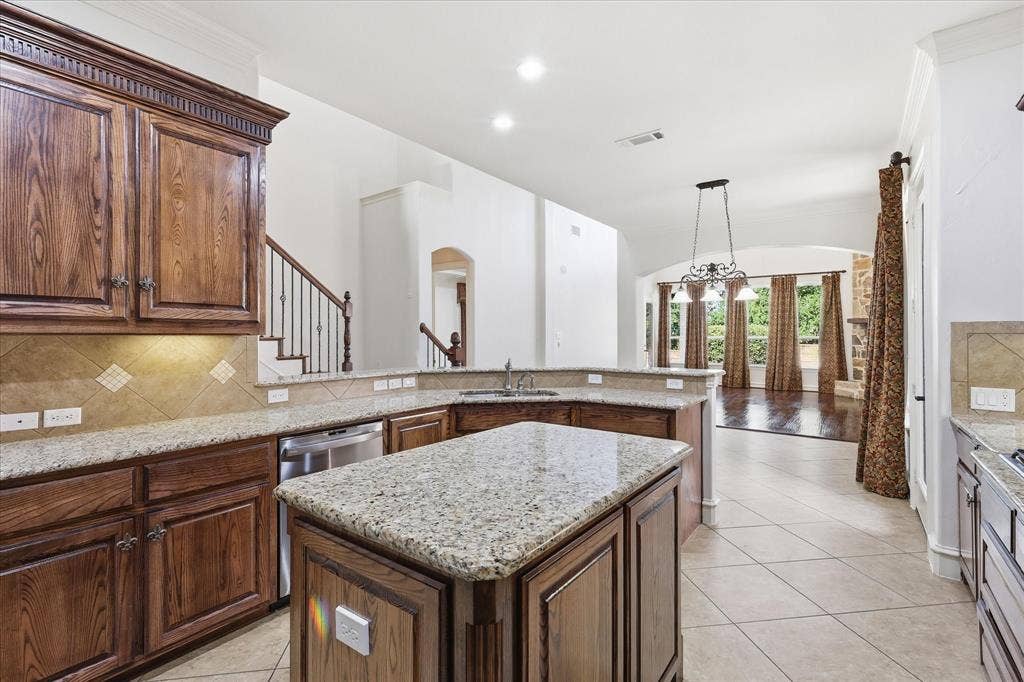420 Silverado Trail, Keller, TX 76248 Open-concept kitchen with granite countertops, wood cabinetry, tile backsplash, and stainless steel appliances