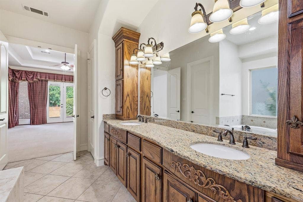 420 Silverado Trail, Keller, TX 76248 Dual vanity with stone countertop, ornate wood cabinetry, and oil-rubbed bronze fixtures