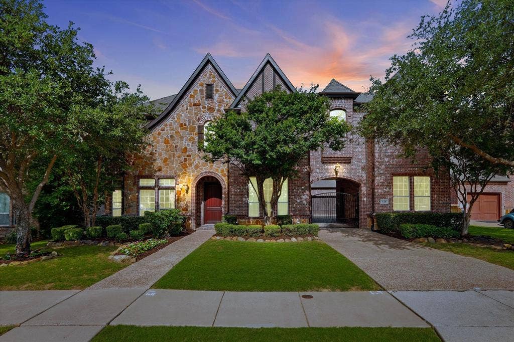 420 Silverado Trail, Keller, TX 76248 Stone and brick exterior with a prominent arched entry, gabled rooflines, and an integrated porte-cochere
