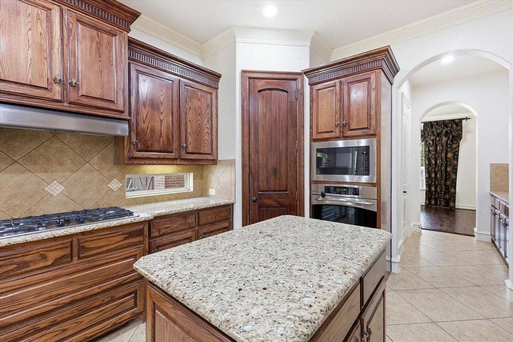 420 Silverado Trail, Keller, TX 76248 Granite countertops, wood cabinetry, tile flooring, stainless steel built-in appliances, and arched doorways