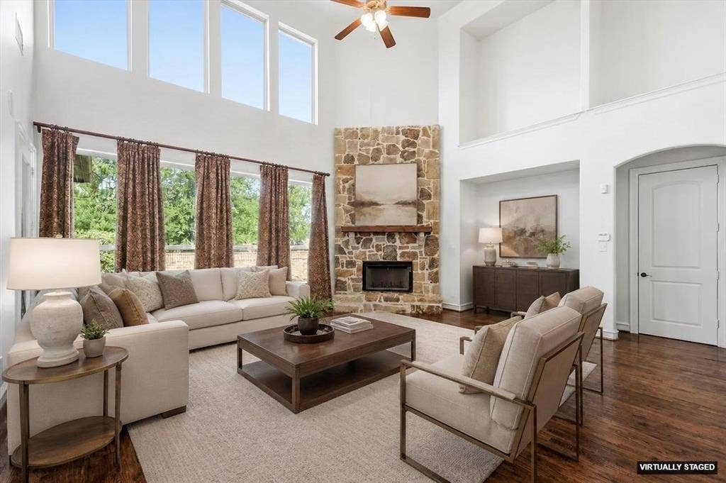 420 Silverado Trail, Keller, TX 76248 Two-story living area featuring a stacked stone fireplace with a wood-finish mantel, dark wood-finish flooring, and high ceilings with upper windows