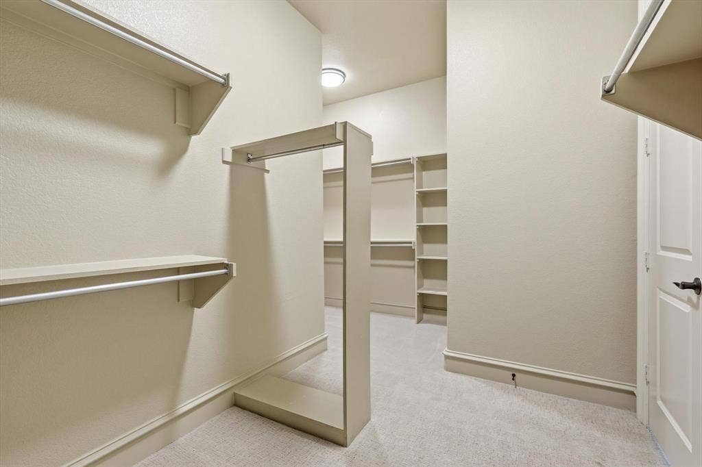 420 Silverado Trail, Keller, TX 76248 Walk-in closet featuring built-in shelving, multiple hanging rods, and neutral carpet