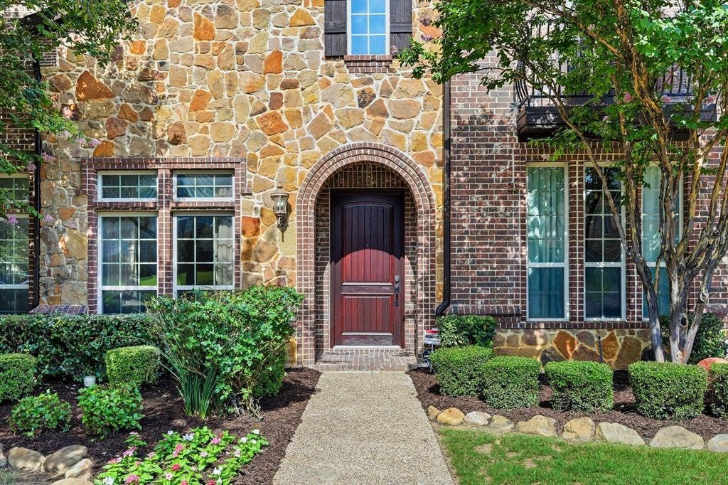 420 Silverado Trail, Keller, TX 76248 Stone and brick facade with an arched entryway, transom windows, and a dark wood door