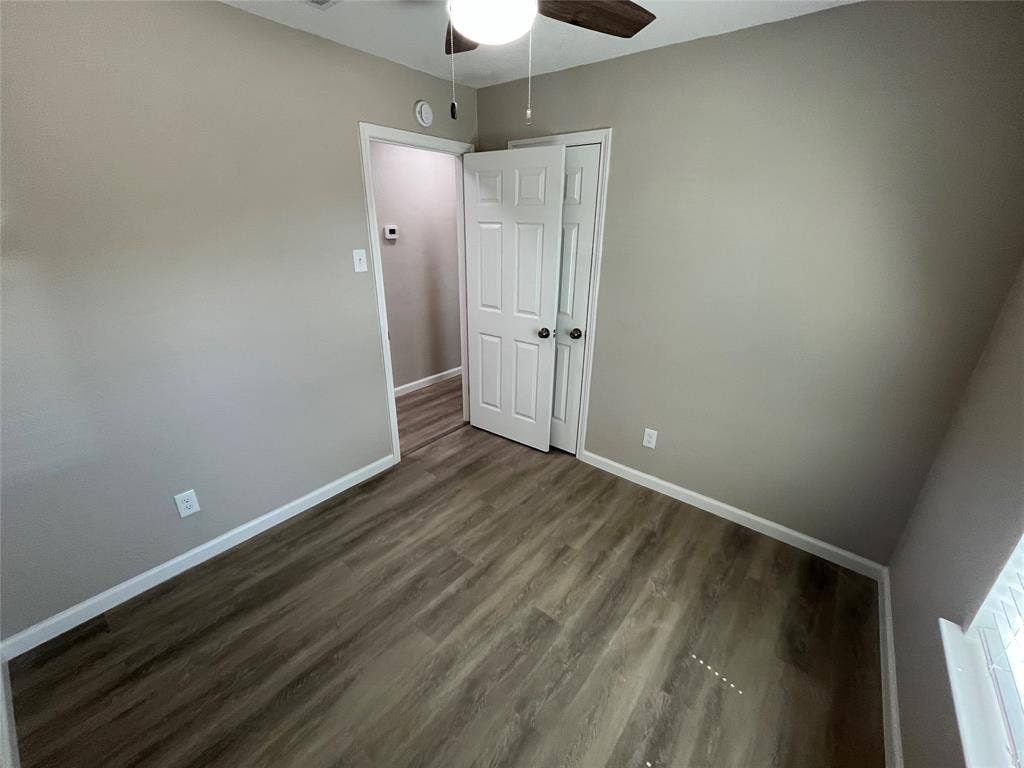 9615 Oak Gate Lane, Dallas, TX 75217 Wood-finish flooring throughout, neutral wall color, and white trim