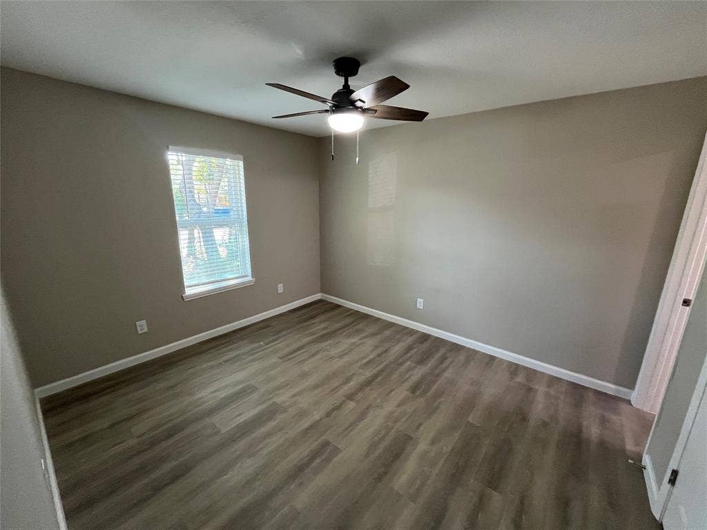 9615 Oak Gate Lane, Dallas, TX 75217 Wood-finish flooring, single window with blinds, ceiling fan with integrated lighting, and neutral wall tones