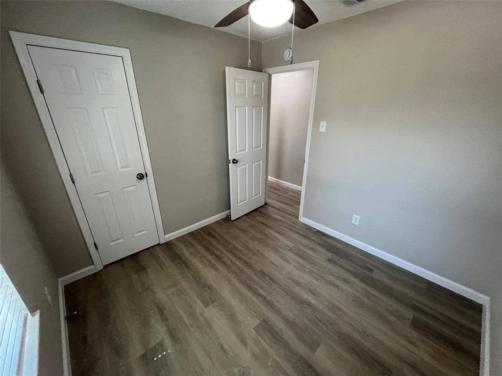 9615 Oak Gate Lane, Dallas, TX 75217 Wood-finish flooring, neutral wall color, ceiling fan with integrated lighting, and white paneled doors