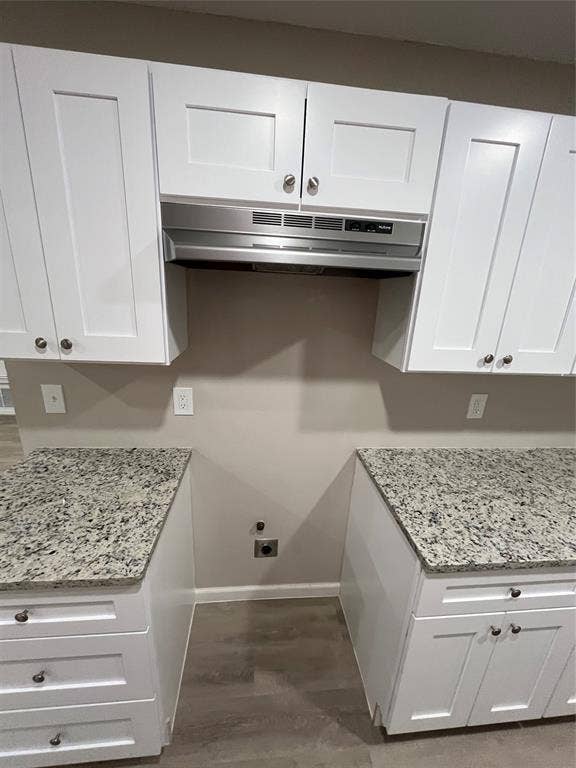 1831 Moonbeam Lane, Carrollton, TX 75006 White shaker-style cabinetry, stainless steel range hood, light-toned wood-finish flooring, and granite countertops