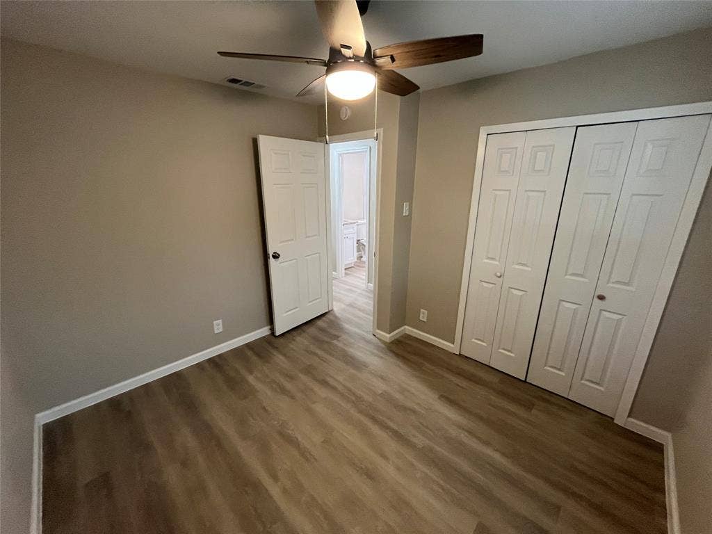 1831 Moonbeam Lane, Carrollton, TX 75006 Wood-finish flooring, ceiling fan with integrated lighting, neutral wall tones, and bi-fold closet doors