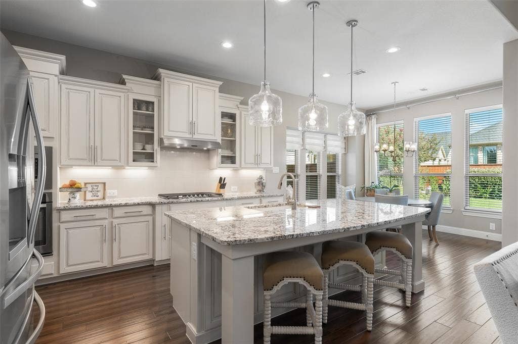 121 Lantana Lane, Wylie, TX 75098 Kitchen featuring white cabinetry, light-colored countertops, stainless steel appliances, and wood-finish flooring