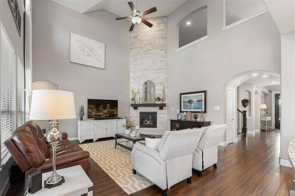 121 Lantana Lane, Wylie, TX 75098 Two-story ceiling, wood-finish flooring, stone-clad fireplace with mantel, ceiling fan, and arched doorways