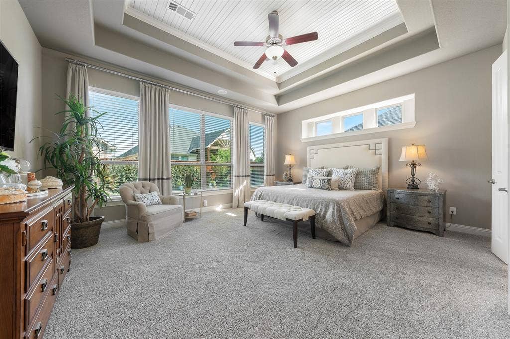 121 Lantana Lane, Wylie, TX 75098 Tray ceiling with shiplap accent, multiple windows with blinds, light gray wall paint, and a ceiling fan with light fixture