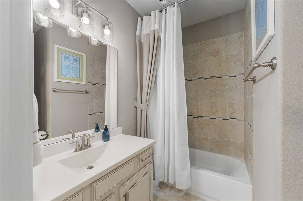 121 Lantana Lane, Wylie, TX 75098 Vanity with an integrated sink, brushed nickel faucet, and a wall-mounted light fixture
