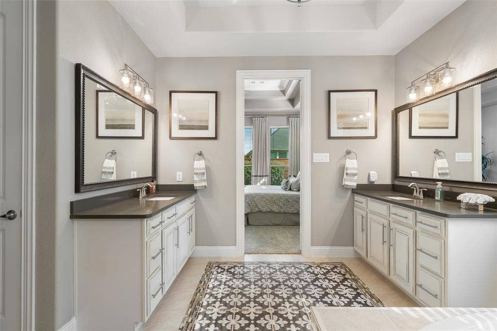 121 Lantana Lane, Wylie, TX 75098 Dual vanities with undermount sinks, dark countertops, and framed mirrors