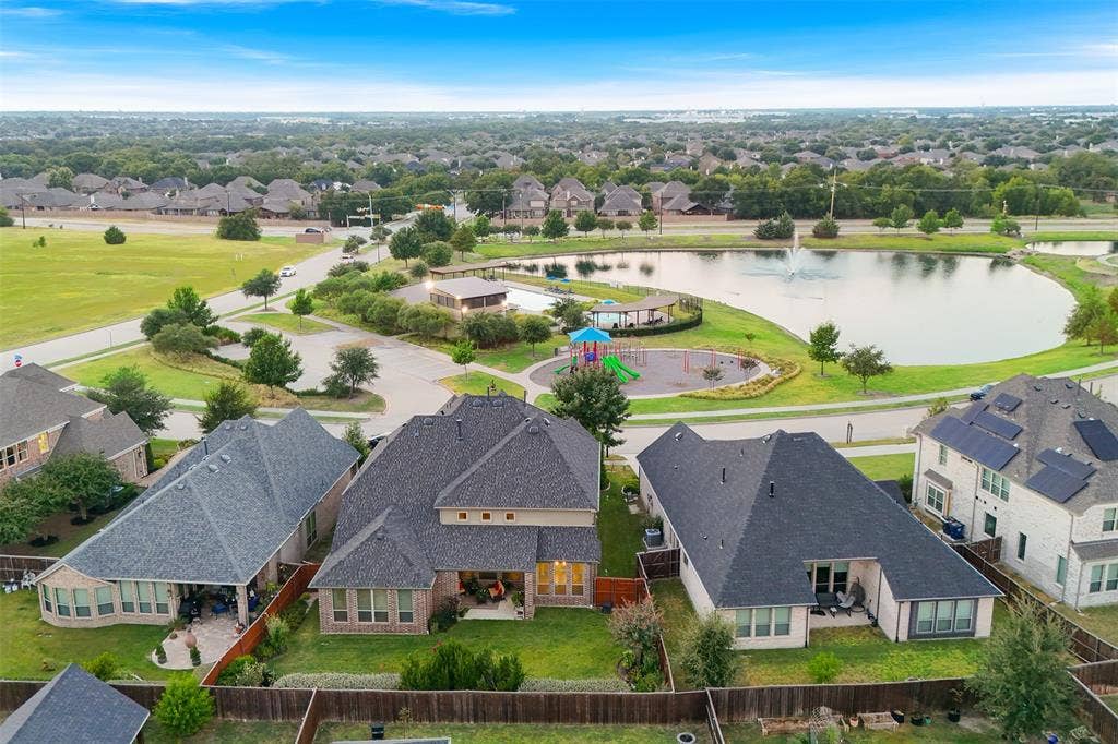 121 Lantana Lane, Wylie, TX 75098 Aerial view showcasing residential properties, a community park with a playground, and a tranquil pond with a water feature