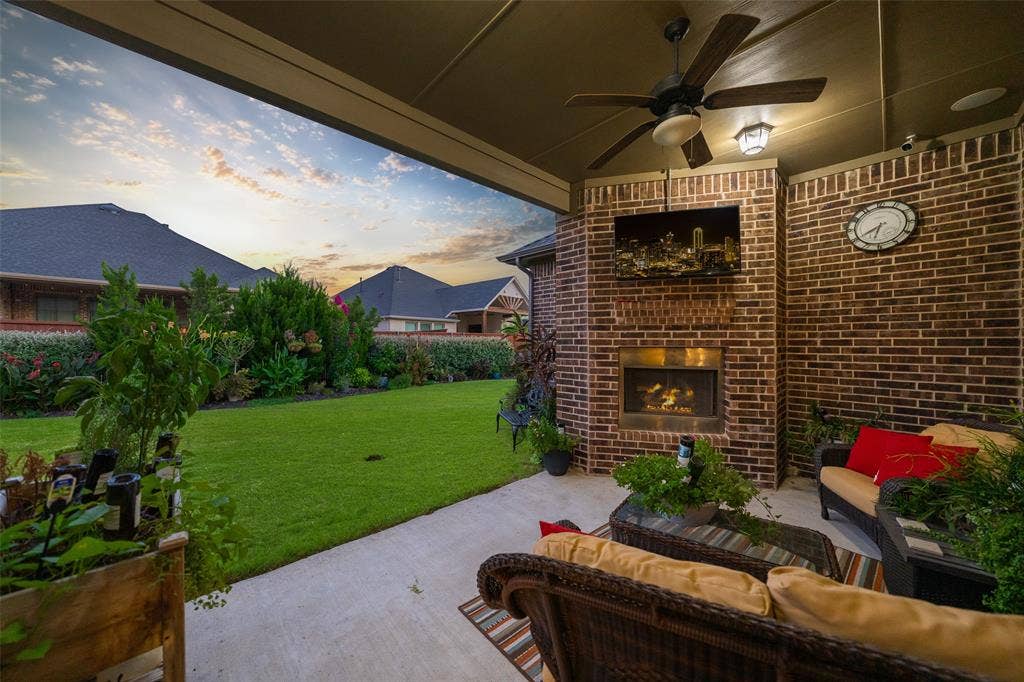 121 Lantana Lane, Wylie, TX 75098 Covered patio with a brick fireplace, built-in television, and ceiling fan