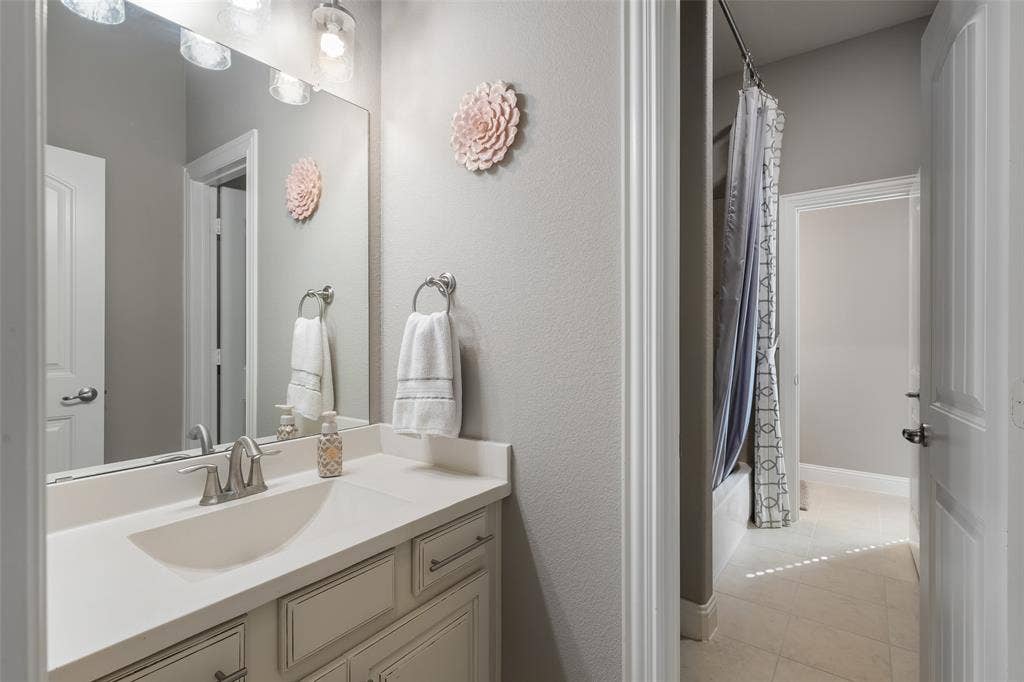 121 Lantana Lane, Wylie, TX 75098 Vanity with integrated sink, brushed nickel faucet, large mirror, and overhead lighting