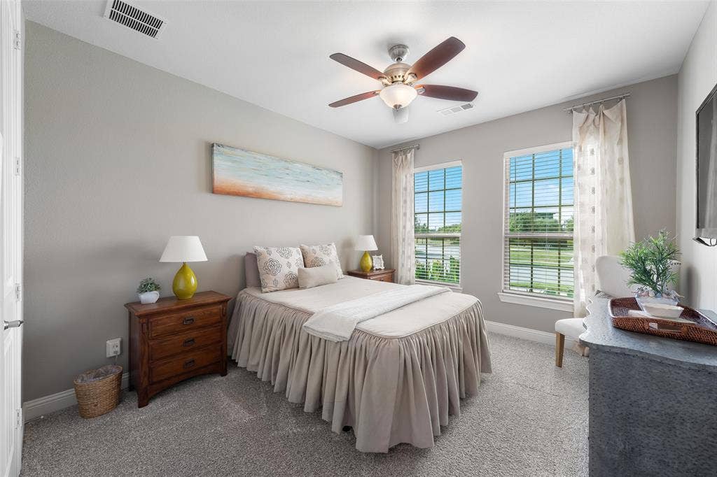 121 Lantana Lane, Wylie, TX 75098 Neutral paint scheme, ceiling fan, two windows with blinds, gray carpeting, and white trim